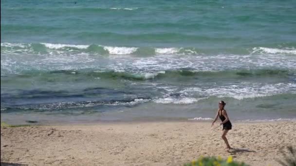 Casal jovem jogando tênis na praia de areia no fundo do mar azul — Vídeo de Stock