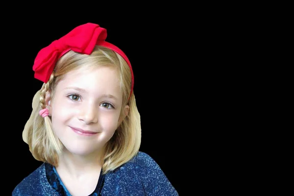 Retrato de una niña pequeña con un lazo rojo en la cabeza —  Fotos de Stock