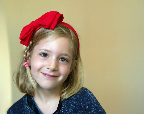 Porträt eines kleinen Mädchens mit roter Schleife auf dem Kopf — Stockfoto
