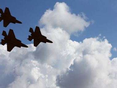 Mavi gökyüzü ve beyaz bulutlar karşı üç F-35 uçaklarının siluetleri