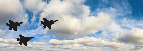 Három F-35 repülőgépek ellen a kék ég és fehér felhők sziluettek — Stock Fotó