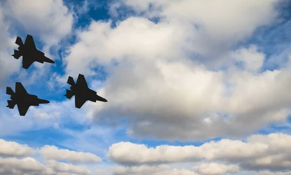 Silhouettes de trois F-35 contre le ciel bleu et les nuages blancs — Photo