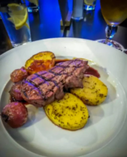 Chutný Grilovaný hovězí steak s pečenými brambory a cibule kroužky podávané na černém plátu. Fotografie v menu. — Stock fotografie