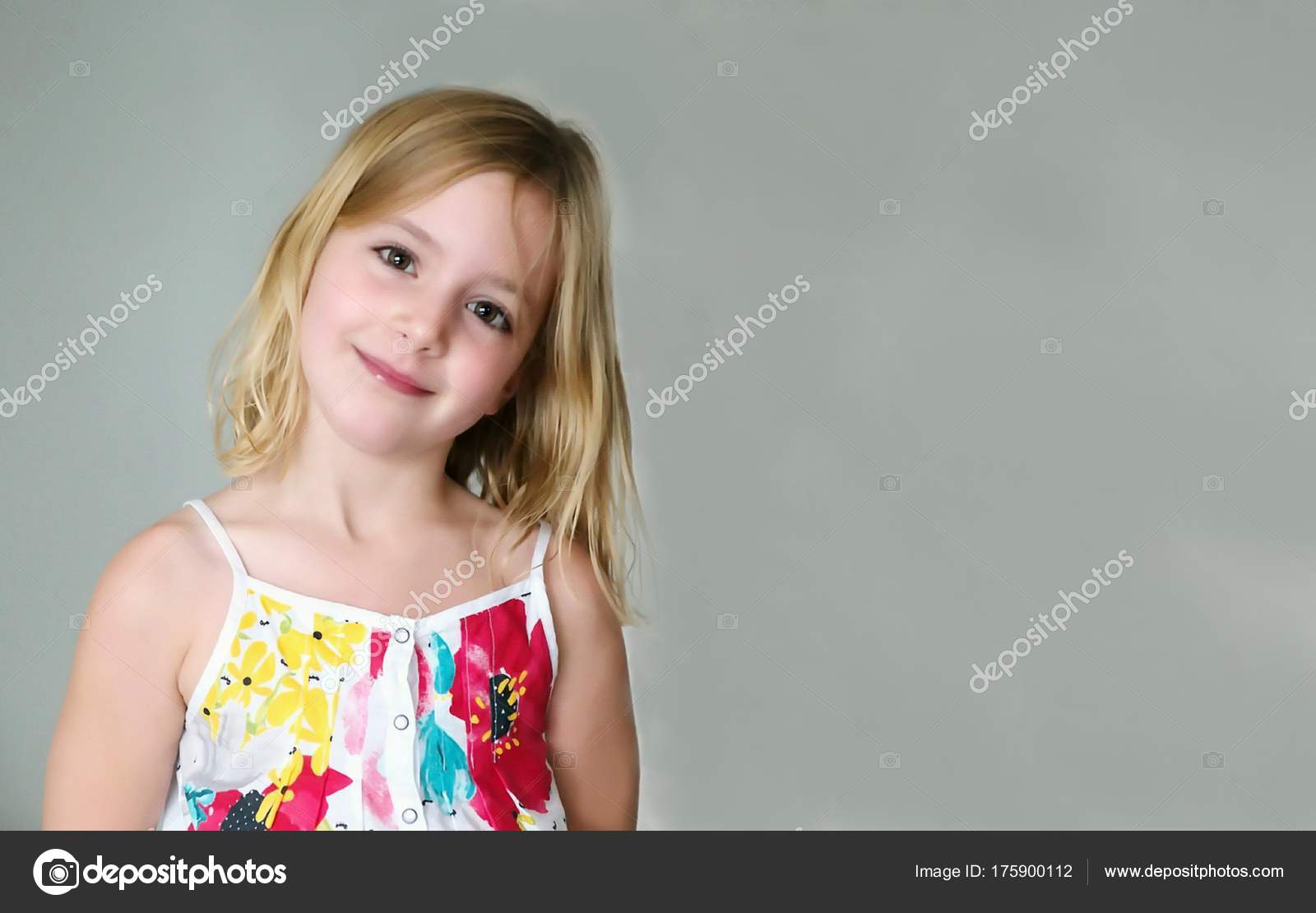 Six Year Old Blonde Girl In A Summer White Dress With Flowers Smiling