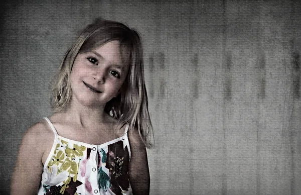 Sechsjähriges blondes Mädchen in einem weißen Sommerkleid mit Blumen auf abstraktem Hintergrund — Stockfoto