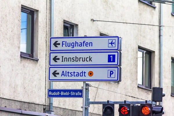 Un semáforo con flechas y una señal de salida para 1 autopistas en dirección a Innsbruck, Aeropuerto y Ciudad Vieja Imágenes De Stock Sin Royalties Gratis