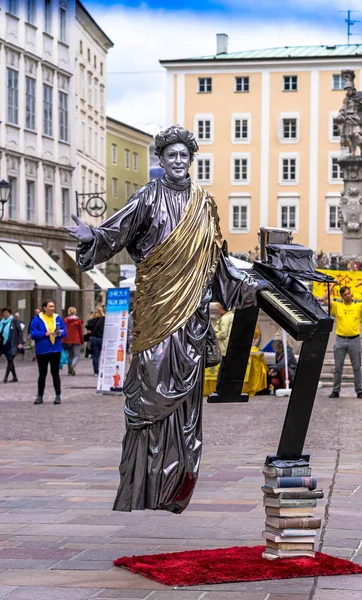 Gatukonstnär som utför levitation knep i gamla centrum av Salzburg, Österrike — Stockfoto