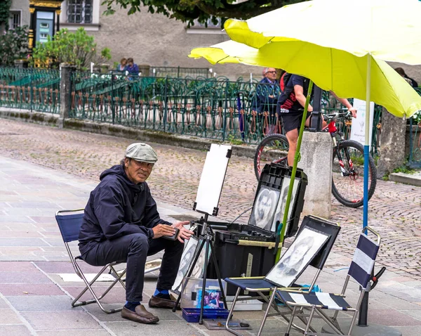 Artista de rua-ilusionista executando truque de levitação no centro antigo de Salzburgo, Áustria — Fotografia de Stock