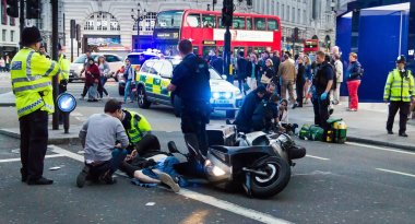 Sağlık görevlileri kurban bir motosiklet kazasında ilk yardım sağlamak. Londra