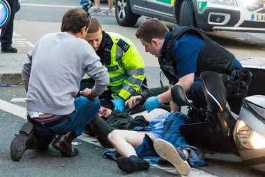 Sağlık görevlileri kurban bir motosiklet kazasında ilk yardım sağlamak. Londra