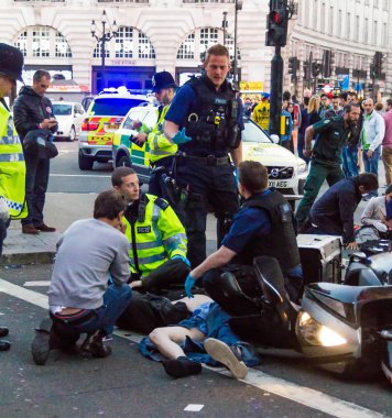 Sağlık görevlileri kurban bir motosiklet kazasında ilk yardım sağlamak. Londra