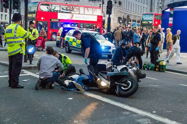 Парамедики оказывают первую помощь пострадавшим в аварии на мотоцикле. Лондон — стоковое фото