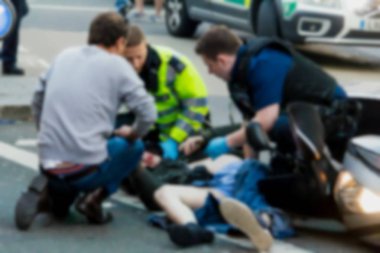 Sağlık görevlileri ve itfaiyeciler mağdur Piccadilly Caddesi üzerinde bir motosiklet kazasında ilk yardım sağlar. Londra. İngiltere'de. Bulanık görünüm