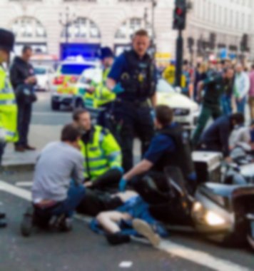 Sağlık görevlileri ve itfaiyeciler mağdur Piccadilly Caddesi üzerinde bir motosiklet kazasında ilk yardım sağlar. Londra. İngiltere'de. Bulanık görünüm