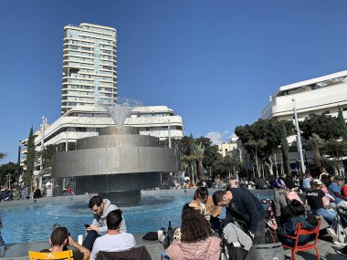 Tel Aviv, İsrail - 23 Ocak 2020: Yeni Dizengoff Meydanı 'ndaki turistler ve yerliler, 2019' da Tel Aviv 'de mavi gökyüzü arka planında yeniden inşa edildikten sonra Ateş ve Su Pınarı ile birlikte