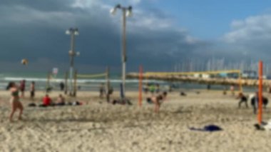 Tanımlanamayan genç kadınlar plaj voleybolu oynuyorlar. 4K