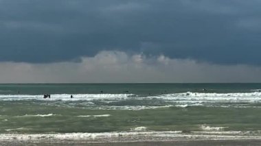 Koyu mavi bulutlu arka planda fırtınalı denizde sörf yapmak. 4K