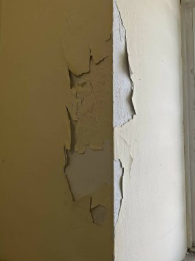 Kırık eski boyalı, iki tonluk alçıdan bir duvar.