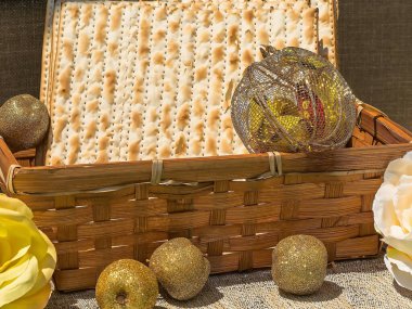 Hasır sepetin içinde siyah arka planda hatıra elmaları ve güllerle dolu bir Matzot. Pesach-Yahudi Paskalyası. Hamursuz Bayramı.