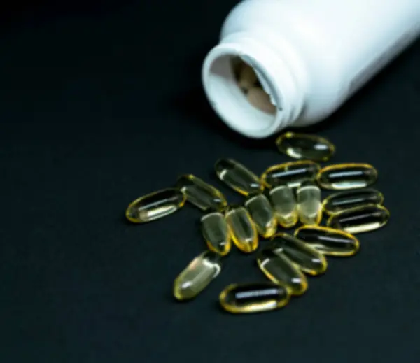 Koyu Arka Planda Balık Yağı Kapsülleri Ilaç Şişesi Omega Bulanık — Stok fotoğraf