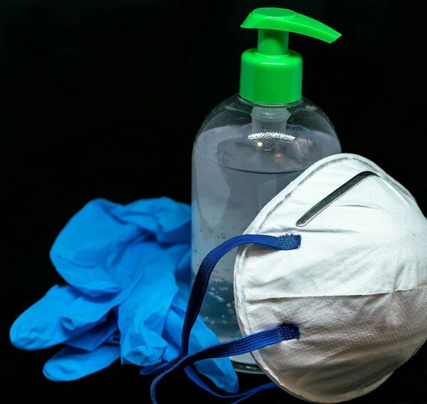 Protective mask , blue latex gloves and transparent white plastic botle with antibacterial sanitizer fluid.