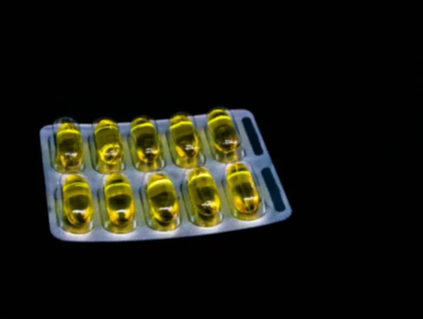 コピースペースが付いている黒い背景のブリスターパックの丸薬かビタミン 医薬品のコンセプト 選択的フォーカス ぼやけた景色 — ストック写真