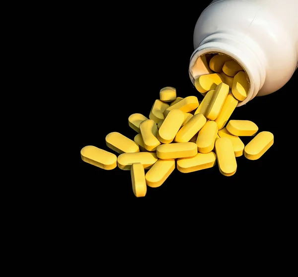 Κίτρινα Δισκία Βιταμίνης Πασπαλισμένα Και Ένα Λευκό Μπουκάλι Χάπια Σκούρο — Φωτογραφία Αρχείου