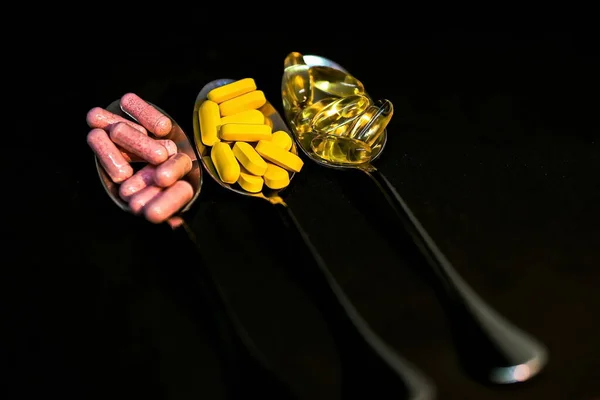 黒を背景に3つのスプーンで薬の概念 選択的焦点 — ストック写真