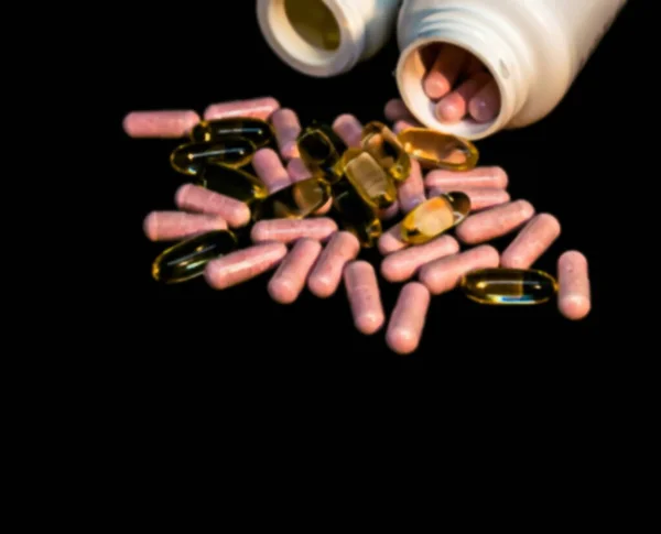 ビタミンDと魚油カプセル オメガ3 と暗い背景に丸薬瓶 ぼやけた景色 — ストック写真