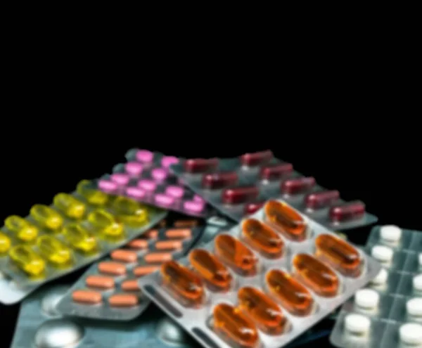 コピースペースが付いている暗い背景のブリスターパックの丸薬及びビタミンの山 医薬品のコンセプト 選択的焦点 — ストック写真