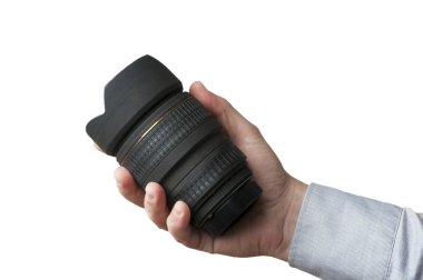 Gömlekli adam beyaz arkaplanda bir DSR kamera lensi tutuyor.