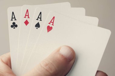 Elinde as olan dörtlü bir poker oyuncusu.