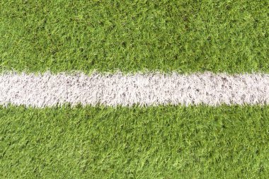 Ortasında beyaz çizgi olan yapay futbol sahası detayı