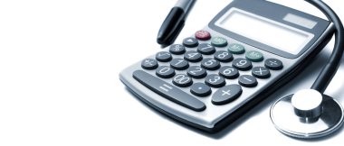 Hesap makinesi ve steteskop beyaz masa üzerinde kalıcı bir mar ile