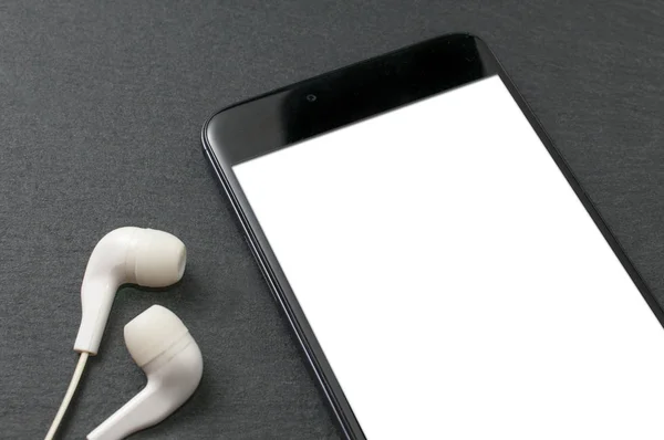 Blank screen smartphone on stone table with a set of white earph — Stock Photo, Image