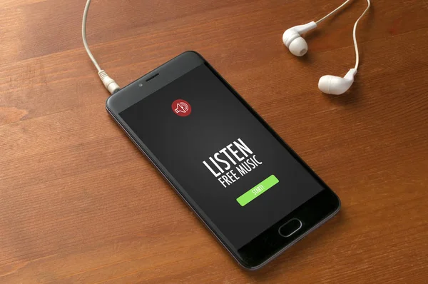 Smartphone prêt à jouer de la musique gratuite et écouteurs blancs sur woode — Photo