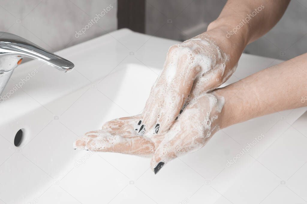 Hand washing techniques: woman rub the palm of her hand with fingertips of the other hand