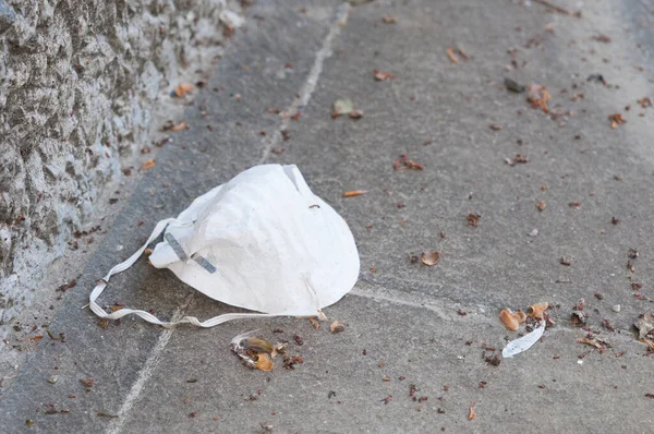 一个粗鲁的人把防护面具扔在街上 — 图库照片