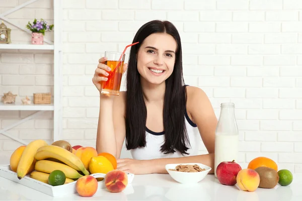 Schöne Frauen mit reiner Haut im Gesicht sitzen an einem Tisch und frühstücken. Asiatin, die sich beim Frühstück gesund ernährt. Obst, Getreide und Milch. — Stockfoto