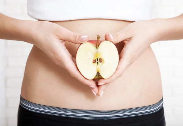 Pregnancy or diet concept, female hands holding apple. — Stock Photo, Image