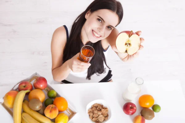 Beautiful women exists with pure skin on her face sitting at a table and eat breakfast. Asian woman eating healthy food at breakfast. Fruit, cereal and milk. — Stock Photo, Image
