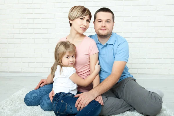 Happy family mother, father and two children playing and cuddling at home on floor — Stock Photo, Image