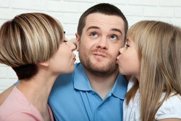 Happy family with child at home. Mother and daughter kissing daddy close up. — Stock Photo, Image