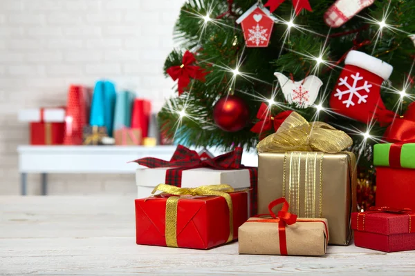 Árvore de Natal com caixas de presente sobre parede de tijolo branco — Fotografia de Stock