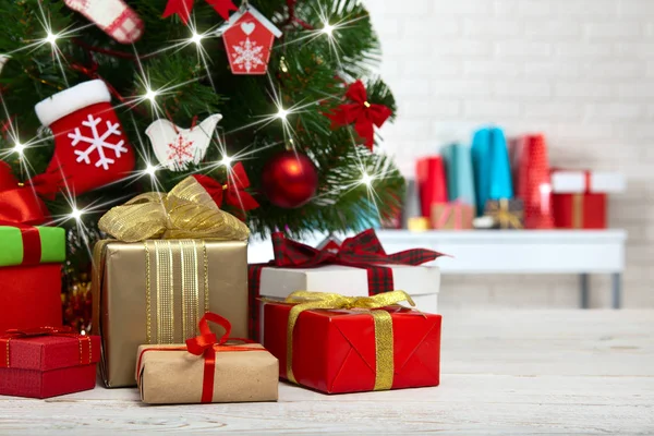 Árvore de Natal com caixas de presente sobre parede de tijolo branco — Fotografia de Stock