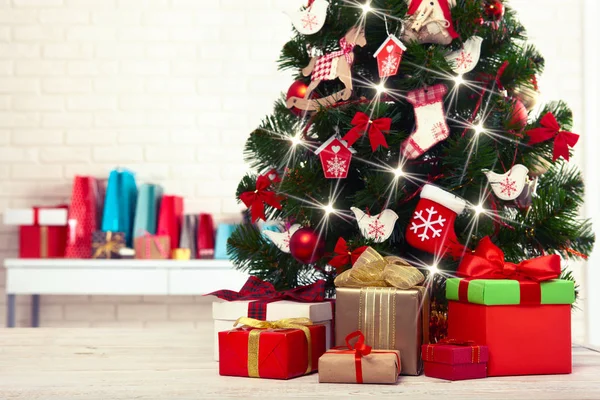 Árvore de Natal com caixas de presente sobre parede de tijolo branco — Fotografia de Stock