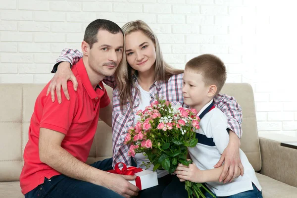 Son hiding bouquet to surprise mommy on mothers day. Woman, man — Stock Photo, Image