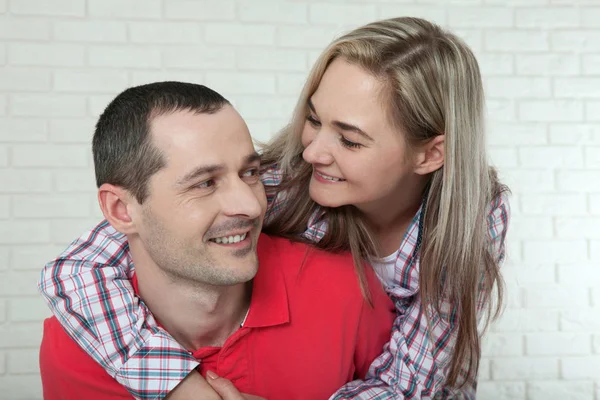 Um jovem casal feliz a sorrir. Homem e mulher abraçando em casa . — Fotografia de Stock