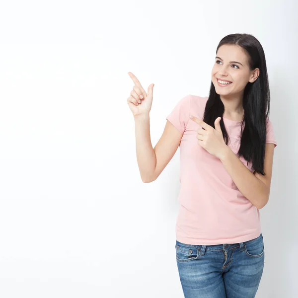 Amichevole donna sorridente che punta a copyspace isolato su sfondo bianco — Foto Stock