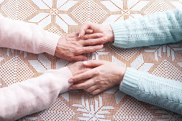 A care is at home of elderly. Holding hands closeup — Stock Photo, Image